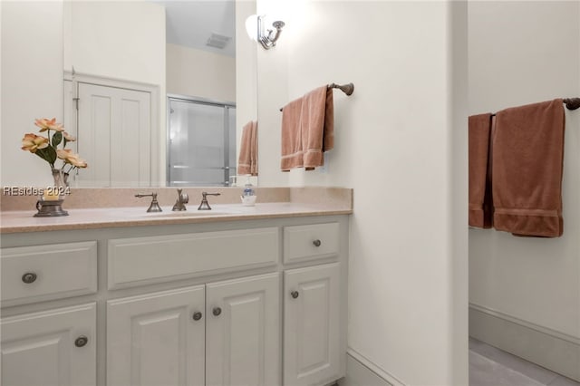 bathroom featuring vanity and a shower with shower door