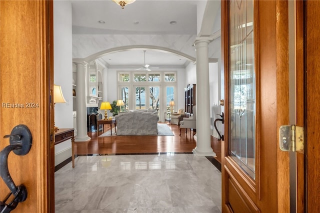 foyer featuring ceiling fan and ornate columns