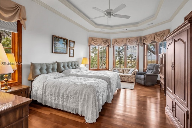 bedroom featuring crown molding, ceiling fan, a tray ceiling, and dark hardwood / wood-style flooring