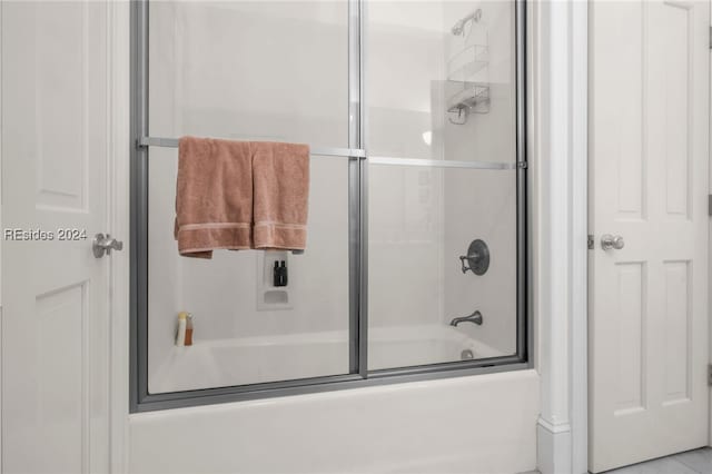 bathroom with combined bath / shower with glass door