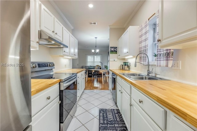 kitchen with wooden counters, appliances with stainless steel finishes, and white cabinets