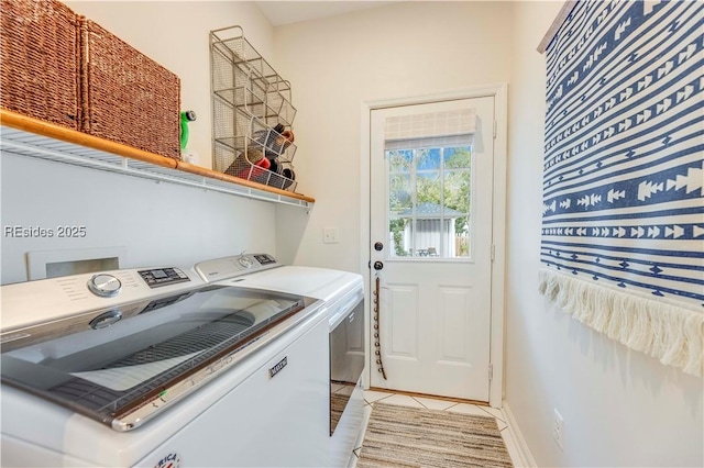 laundry area featuring washer and clothes dryer and light tile patterned floors