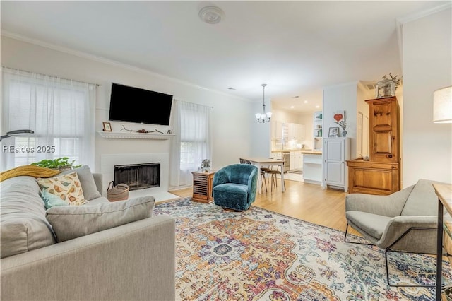 living room featuring crown molding, a chandelier, and hardwood / wood-style floors