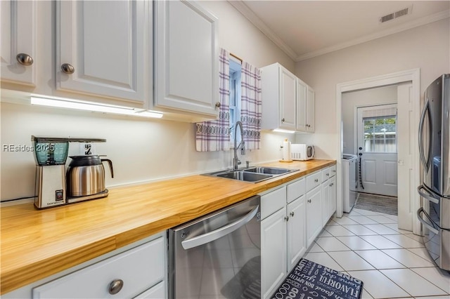 kitchen featuring wood counters, sink, white cabinetry, ornamental molding, and stainless steel appliances