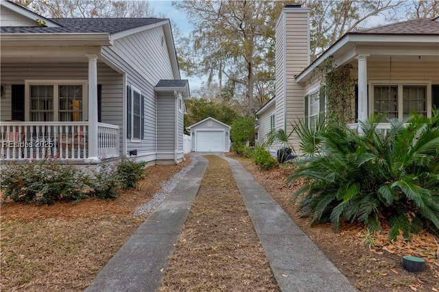 view of home's exterior featuring an outbuilding, a garage, and covered porch