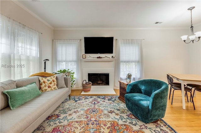 living room featuring ornamental molding, hardwood / wood-style floors, and a chandelier