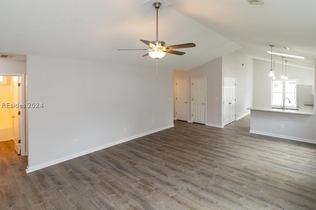 unfurnished living room with sink, vaulted ceiling, dark hardwood / wood-style floors, and ceiling fan