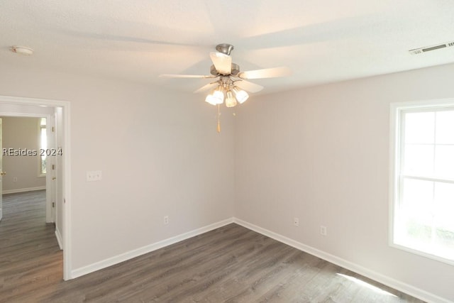 spare room featuring ceiling fan, plenty of natural light, and dark hardwood / wood-style flooring