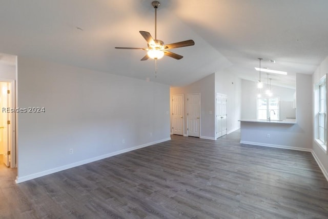 unfurnished living room with lofted ceiling, sink, dark wood-type flooring, and ceiling fan