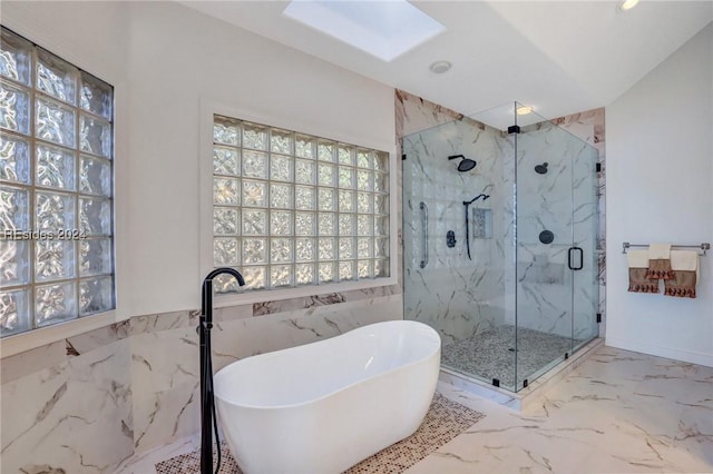 bathroom featuring plus walk in shower, a skylight, and tile walls