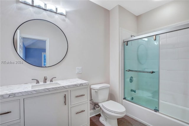 full bathroom featuring vanity, toilet, and combined bath / shower with glass door