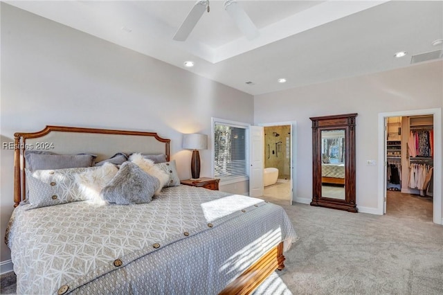 carpeted bedroom featuring connected bathroom, a walk in closet, a closet, and ceiling fan