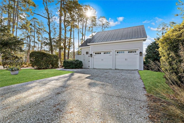 view of side of property featuring a garage and a lawn