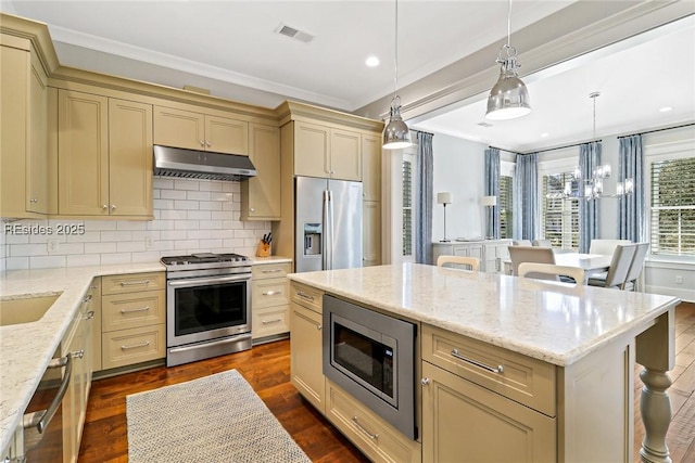 kitchen featuring appliances with stainless steel finishes, dark hardwood / wood-style floors, a center island, tasteful backsplash, and decorative light fixtures