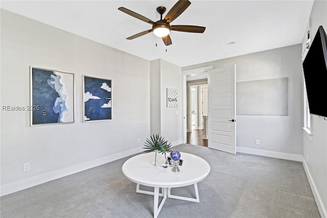 living area featuring carpet and ceiling fan