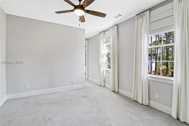 carpeted empty room featuring plenty of natural light and ceiling fan