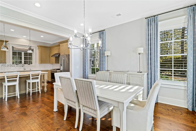 dining space featuring ornamental molding, sink, an inviting chandelier, and dark hardwood / wood-style flooring