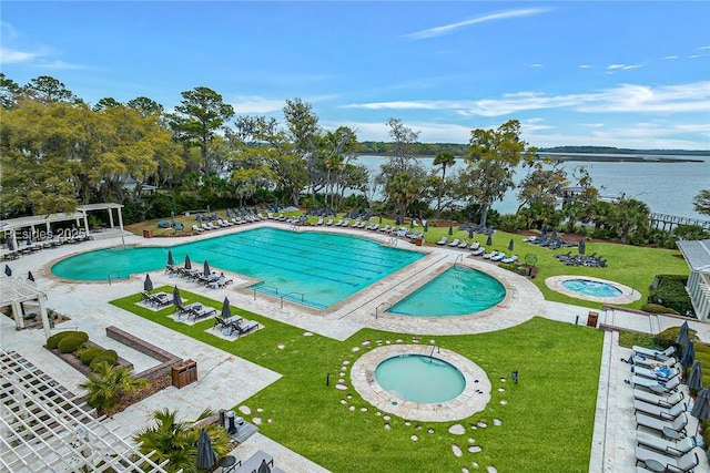 view of swimming pool featuring a water view, a patio, a community hot tub, and a lawn