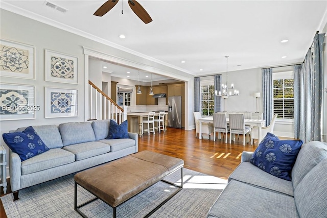 living room featuring crown molding, ceiling fan with notable chandelier, and dark hardwood / wood-style flooring