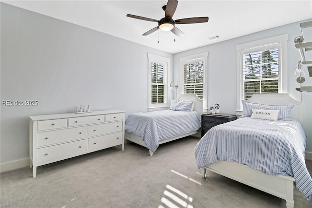 carpeted bedroom with multiple windows and ceiling fan