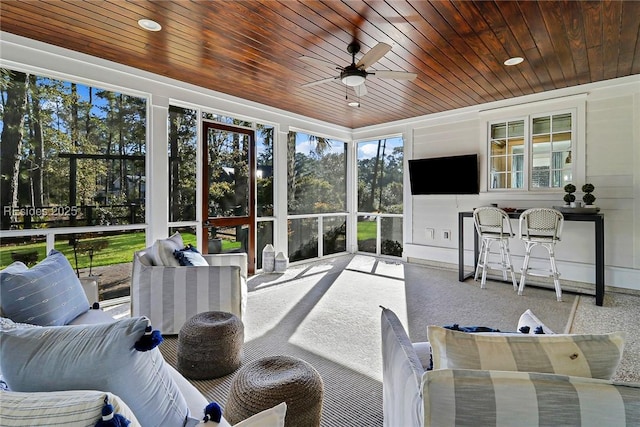 sunroom featuring wood ceiling and ceiling fan