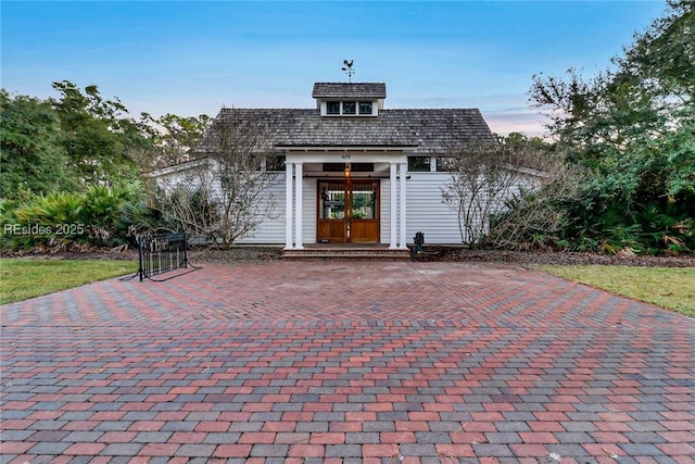 exterior entry at dusk featuring french doors