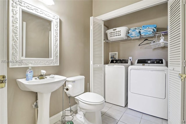 bathroom featuring tile patterned floors, toilet, and washing machine and clothes dryer