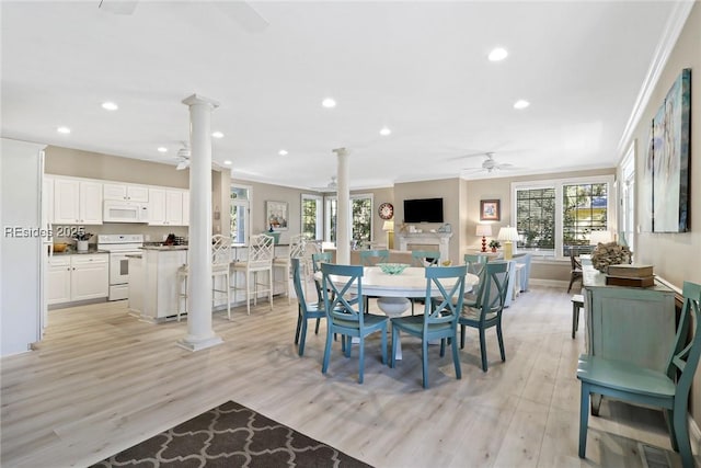 dining area featuring crown molding, ceiling fan, light wood-type flooring, and ornate columns