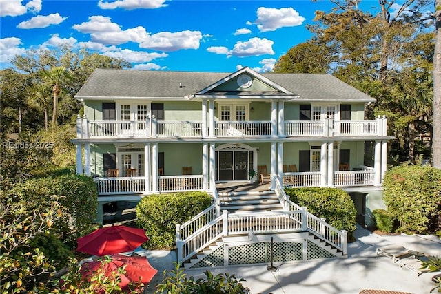 view of front facade featuring a balcony, covered porch, and french doors