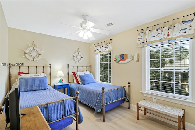 bedroom featuring multiple windows, wood-type flooring, and ceiling fan