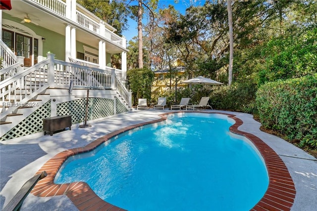 view of swimming pool featuring ceiling fan and a patio