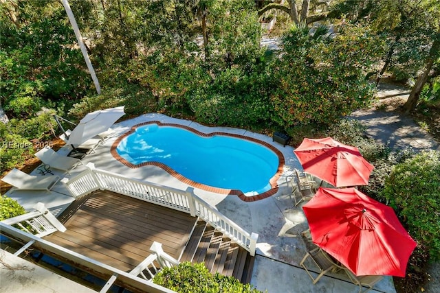 view of pool with a wooden deck and a patio