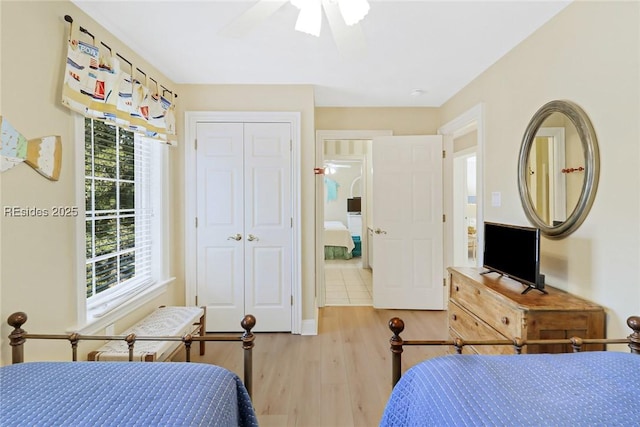 bedroom with light hardwood / wood-style flooring, ceiling fan, and a closet