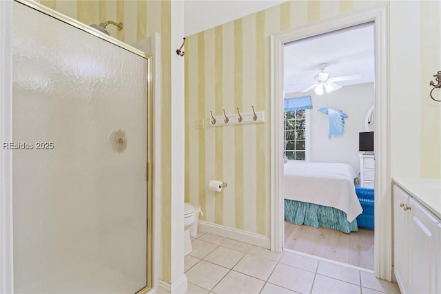 bathroom featuring ceiling fan, toilet, tile patterned flooring, and a shower with door