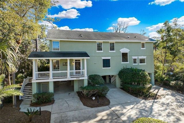 back of house with a porch and a carport