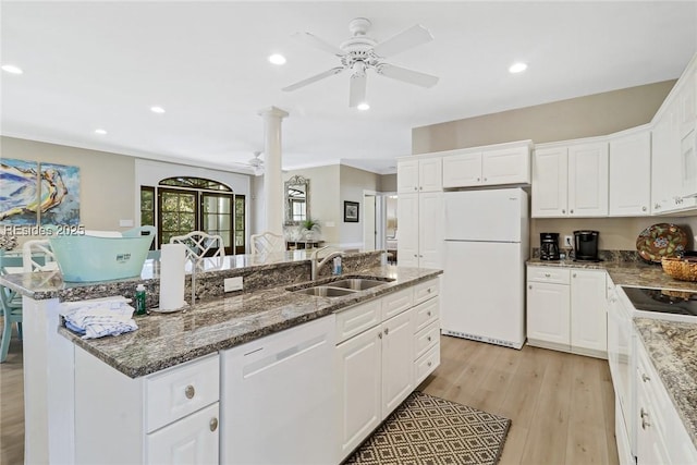 kitchen with white cabinetry, white appliances, an island with sink, and sink