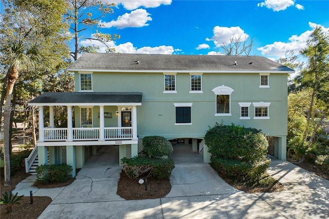 rear view of property with a carport and covered porch