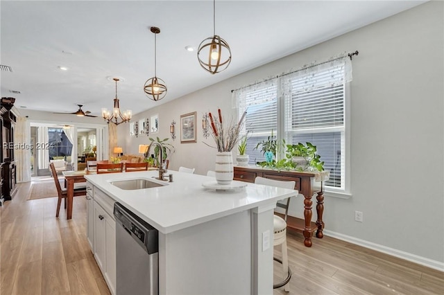 kitchen with sink, dishwasher, white cabinets, a center island with sink, and decorative light fixtures