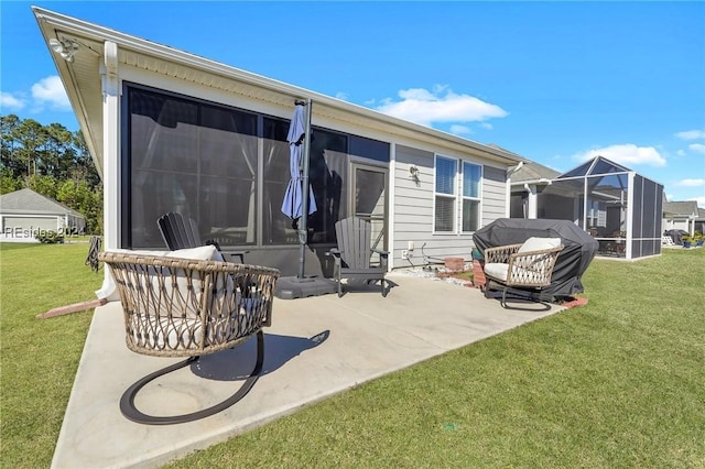 back of property featuring a yard, glass enclosure, and a patio