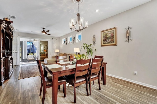 dining area featuring ceiling fan with notable chandelier and light hardwood / wood-style flooring