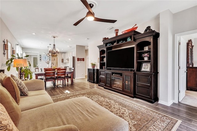 living room featuring hardwood / wood-style floors and ceiling fan with notable chandelier