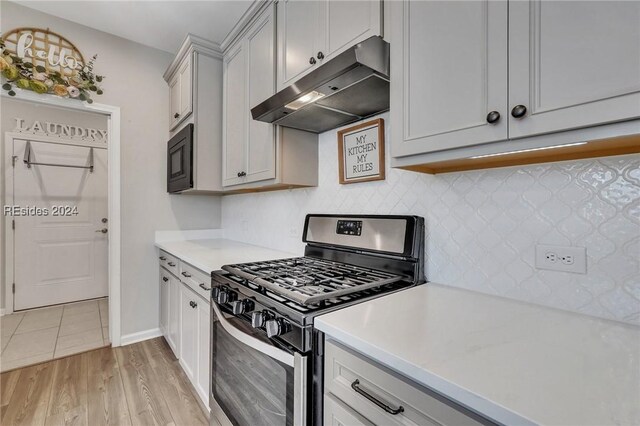 kitchen featuring built in microwave, stainless steel gas range, and light hardwood / wood-style flooring