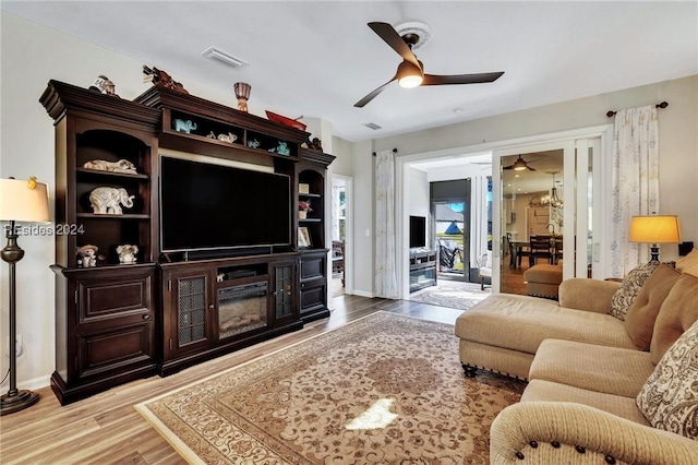 living room with light hardwood / wood-style floors and ceiling fan