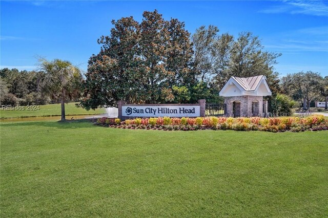 community / neighborhood sign featuring a lawn