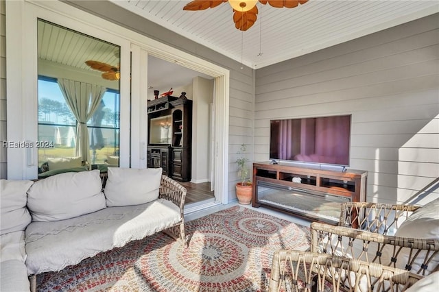 living room with ceiling fan and wooden walls