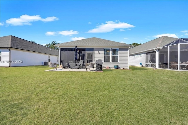 rear view of property with a yard, a sunroom, and a patio area