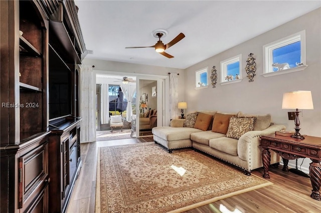 living room with light hardwood / wood-style floors and ceiling fan