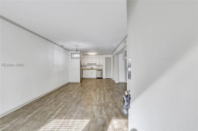 unfurnished living room with sink, light hardwood / wood-style flooring, and a chandelier