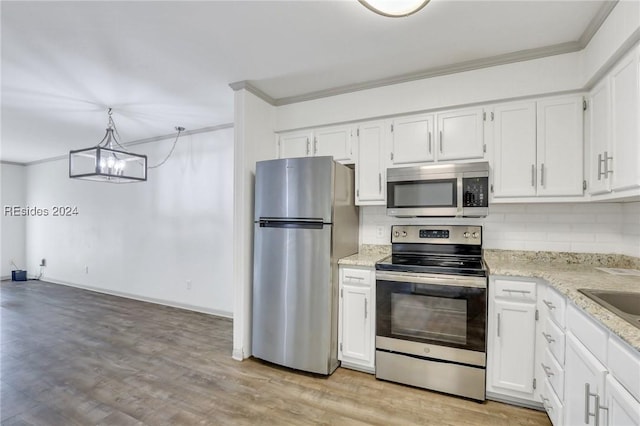 kitchen featuring pendant lighting, tasteful backsplash, stainless steel appliances, and white cabinets