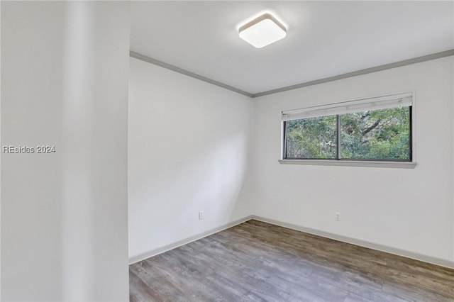 unfurnished room featuring hardwood / wood-style flooring and ornamental molding